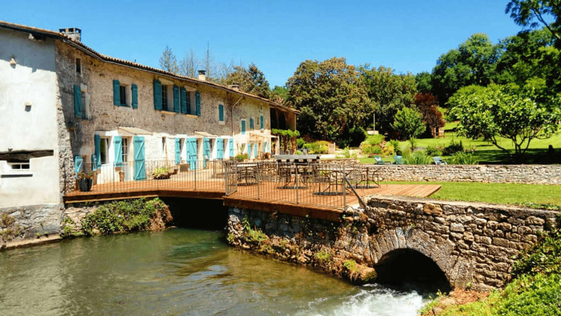 Moulin avec eau et chaises au soleil