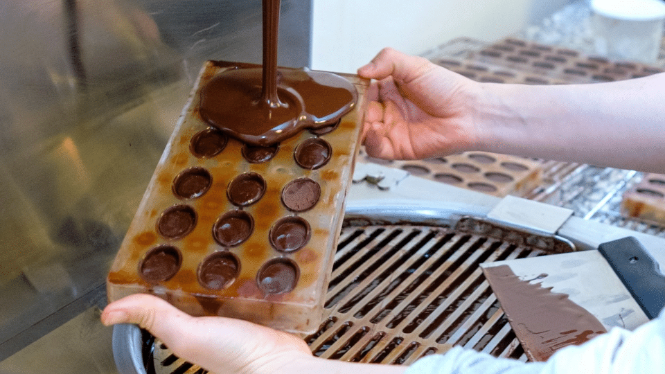 Pâtissière en train de remplir un moule à chocolat. Animation originale pour un événement