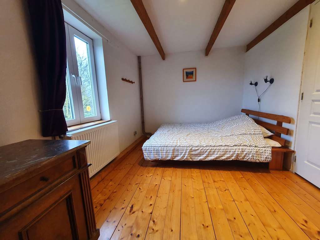 Chambre avec lit double et parquet de bois