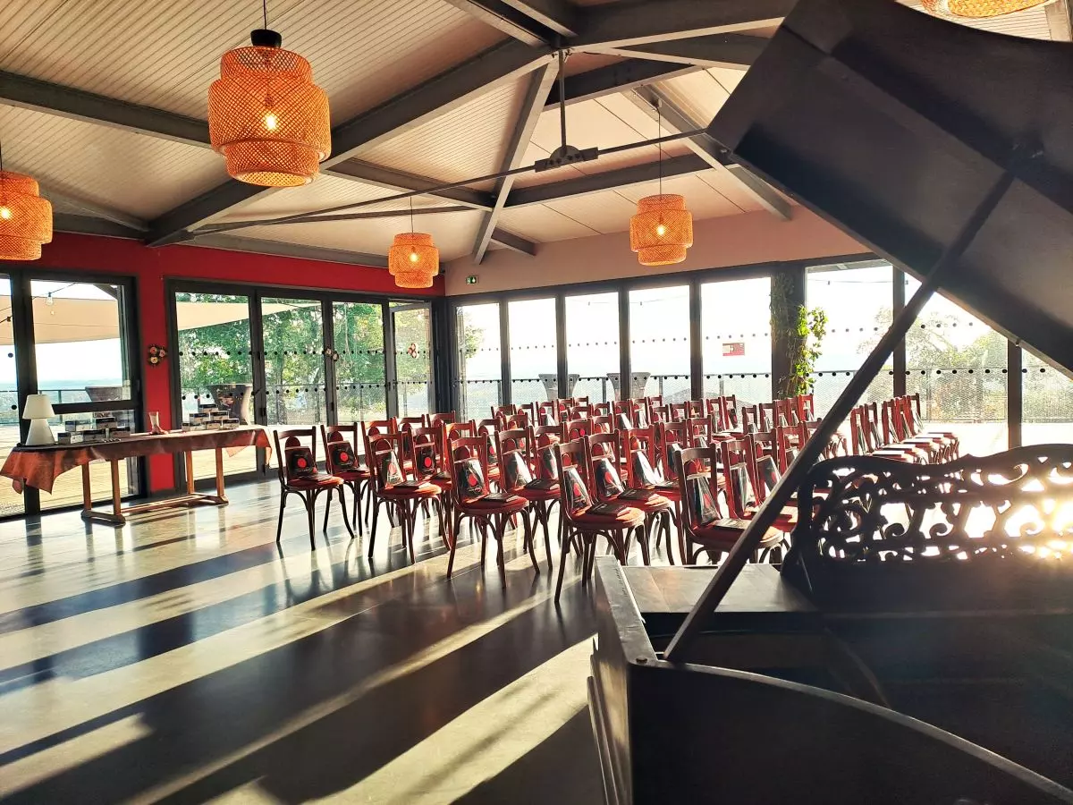 Événement professionnel au Château Réaut dans une salle lumineuse et élégante, offrant une vue imprenable grâce à ses grandes baies vitrées, idéal pour conférences ou séminaires.