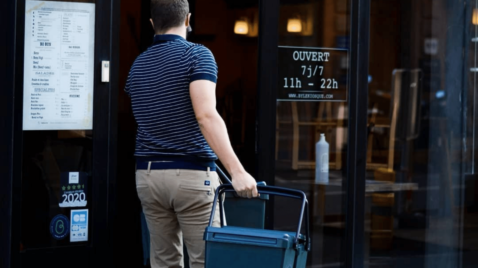 Un homme de dos qui récupère une poubelle de biodéchets