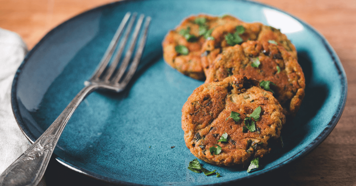 Assiette bleue avec galettes végétales et fourchette