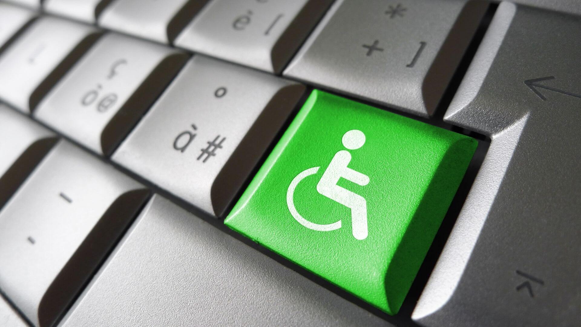 Touche sur clavier d'ordinateur avec dessin fauteuil roulant : accessibilité établissement handicap